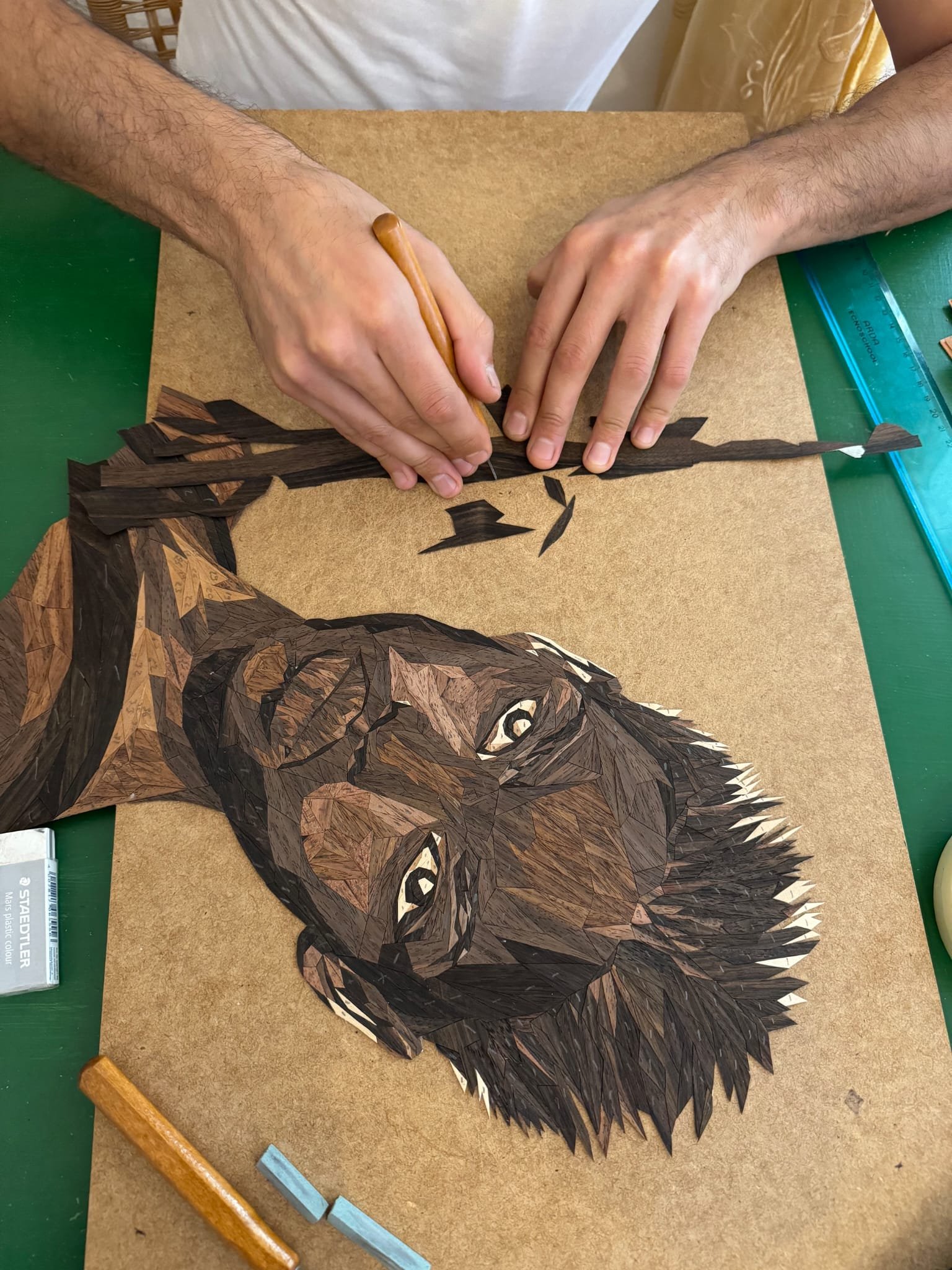 Hand-cutting wood veneer pieces for a marquetry portrait